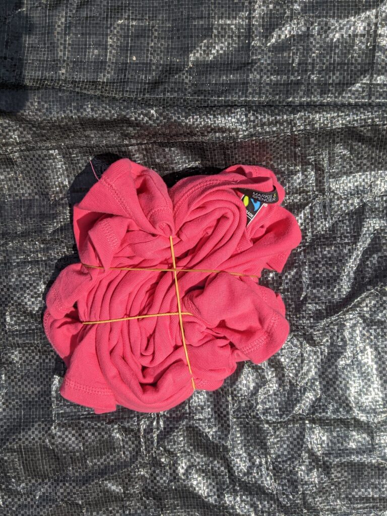 Shirt already tied and held with rubber bands, ready for the reverse tie-dye process
